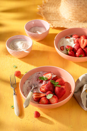 Creamy and delicious strawberries as summer fresh dessert. Berry fruits with cream and sugar.の写真素材
