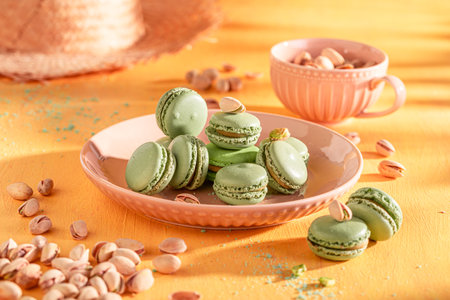 Tasty and homemade pistachio macarons on plate on yellow background. Green macarons made of nuts.の写真素材