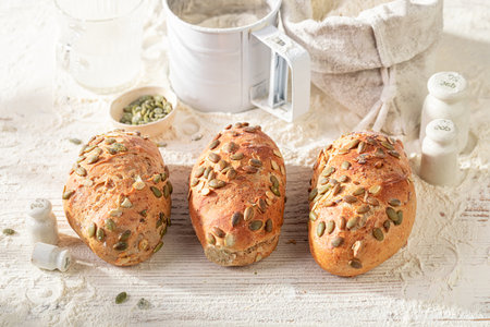 Hot buns with pumpkin seeds made of sourdough and flour. Rolls baked in a bakery.