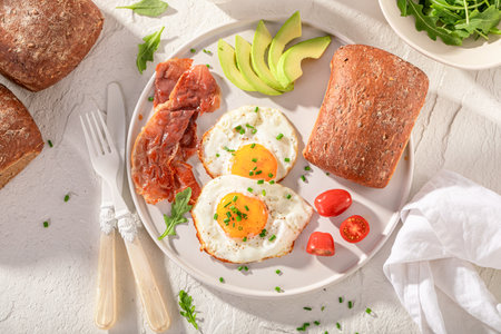 Healthy and fresh breakfast with buns, fried eggs and chive. British breakfast.の写真素材