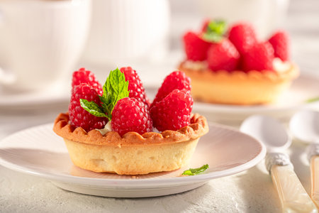 Tasty and homemade mini tart as an summer cake with coffee. Cake with raspberries and cream.の写真素材