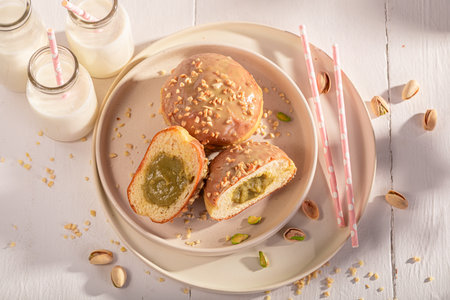 Fresh and tasty pistachio donuts for Fat Thursday. Served with milk. Most popular dessert.の写真素材