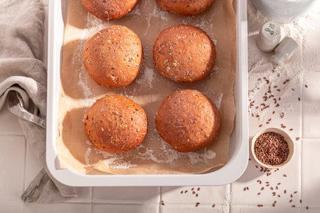 Hot and tasty flax seed buns in rustic bakehouse. Flax seed rolls and ingredients in the bakery.の写真素材