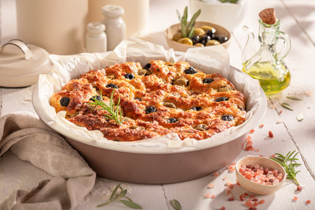 Tasty focaccia with olive oil and olives. Classic Italian cuisine. Focaccia made of simple ingredients.の写真素材