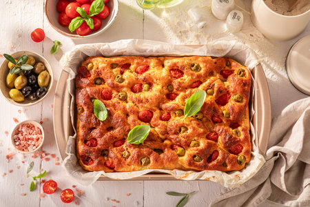 Traditional focaccia with green olives and cherry tomatoes. Classic Italian cuisine. Focaccia made of fresh ingredients.の写真素材