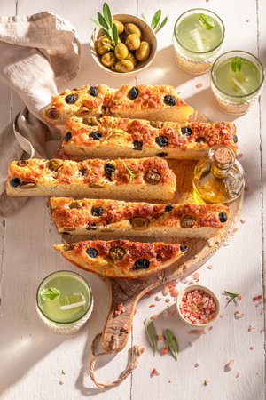 Homemade and tasty focaccia with olives served with lemonade.の写真素材
