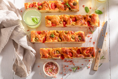 Traditional and fresh focaccia with tomatoes and served with lemonade.の写真素材