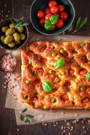 Homemade focaccia made of flour, olives and cherry tomatoes. Poster for Restaurant. Focaccia with tomatoes and olives.の写真素材