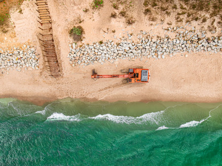 Aerial view of construction work on the beach and an excavator. Industry on the Baltic Sea.の写真素材