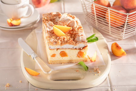 Delicious and tasty peach cheesecake served on white kitchen. Peach cheesecake with cocoa.の写真素材