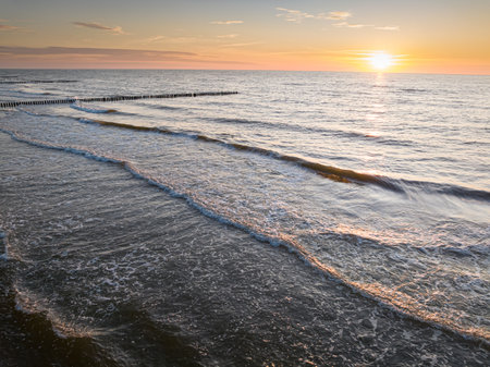 Waves and sun on horizon at Baltic Sea at sunset, aerial view of Polandの写真素材