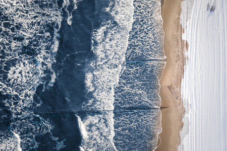 Aerial view of nature in winter. Cold Baltic sea and snowy beach at winter.