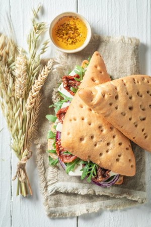 Tasty and tasty sandwich with arugula, cheese and dried tomatoes. Filling sandwich with cheese and...