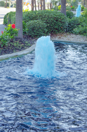 blue fountain in a pondの写真素材