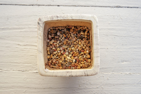 Pebbles in the wooden plant potの写真素材