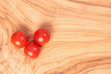Tomatoes cherry on a dark brown wooden background.の写真素材