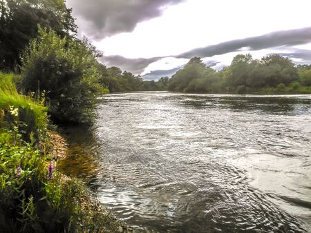 Busy river view with cloudy, luminous skyの写真素材