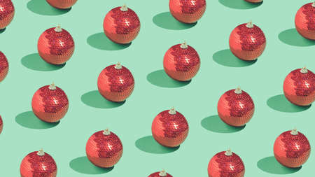 Retro New Year or Christmas pattern with bright red baubles on green background. Creative vintage party concept.の写真素材