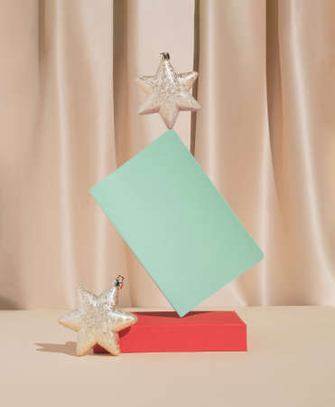 Christmas or New Year composition with golden holiday star ornaments and mint green notebook. Minimal New Year resolutions concept.の写真素材