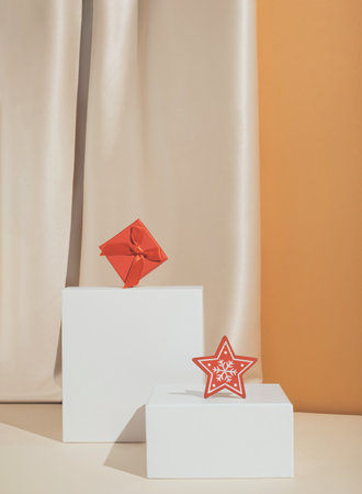 Minimal stylish Christmas or New Year composition with star ornament and red gift box on elegant silk background.の写真素材