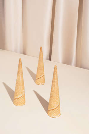 Minimal modern summer composition with three ice cream cones on stylish silk background. Trendy retro concept.の写真素材