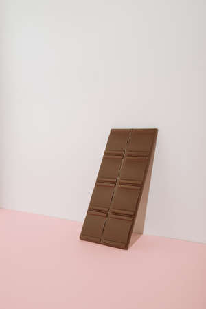 Minimal modern concept with  chocolate bar on pastel background. Trendy aesthetic with copy space.の写真素材