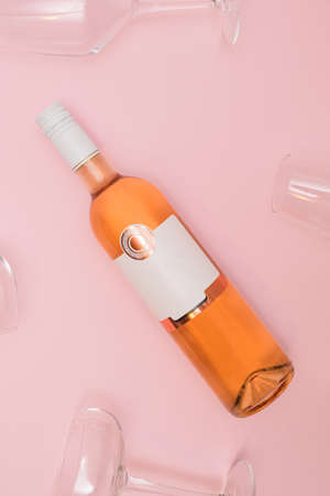 Elegant rose wine bottle and glasses on pastel pink background. Modern Valentine's Day date concept.の写真素材