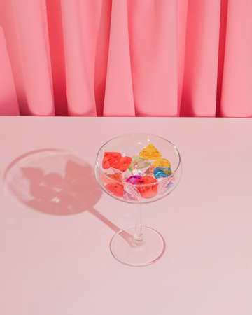 Romantic Valentine or birthday party composition made with wine glass and colorful gemstones. Vibrant and bright modern concept.の写真素材