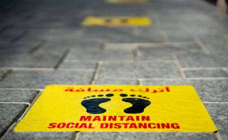 Maintain Social distancing stickers pasted on the floor in front of the restaurant in Qatar Qatarの写真素材