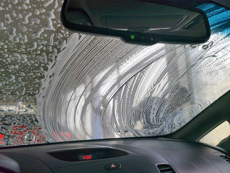 Dirty car getting washed.Washing the dirty car manually in a car wash shopの写真素材