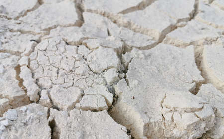 Dry desert clay floor cracked due to summer and drought.Cracked ground or mud cracks on earth surface background. It sedimentary structures formed as muddy sediment dries and contracts.の写真素材
