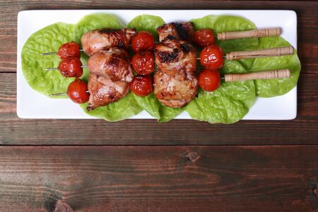grilled barbecue kebab chicken legs and tomatoes on skewersの写真素材