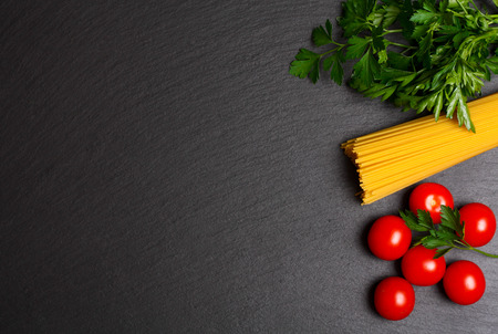 Raw pasta with tomatoes and parsleyの写真素材