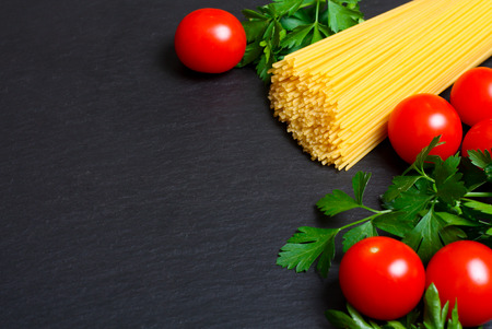 Raw pasta with tomatoes and parsleyの写真素材