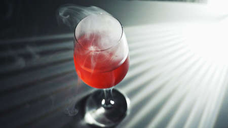 A glass of red drink in the dazzling lightの写真素材