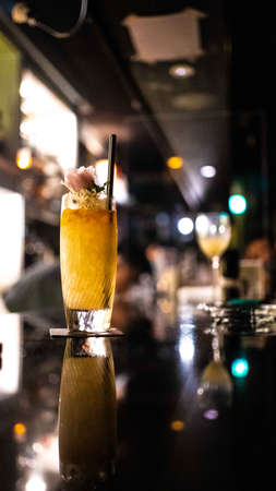 A glass of golden ice cold drink in the barの写真素材