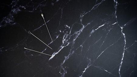 Three metal fruit fork on black marble backgroundの写真素材
