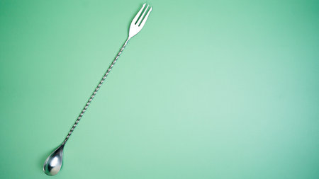 A bar spoon on a bright green backgroundの写真素材