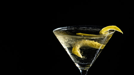 A glass of cocktail with lemon zest on a black backgroundの写真素材