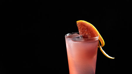 A glass of grapefruit drink on a black backgroundの写真素材