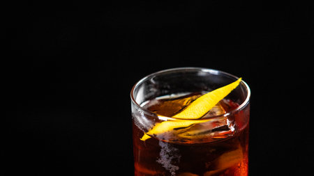 A glass of Negroni cocktail on a black backgroundの写真素材