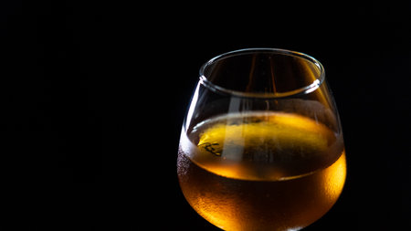 A glass of brandy on a black background with copy space.の写真素材