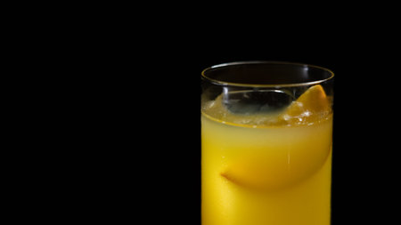 Orange juice in a glass on a black background. Close-up.の写真素材