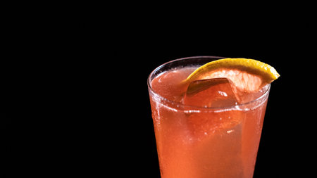 Alcoholic cocktail drink on a black background with a slice of grapefruitの写真素材
