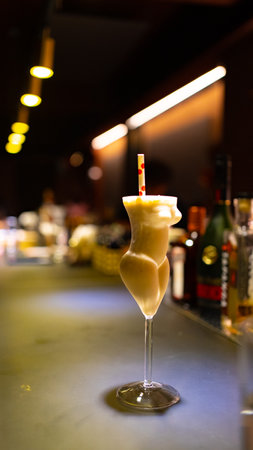 Cocktail in a glass with a straw on a bar counterの写真素材