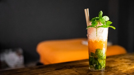 Mojito cocktail in a glass with ice and mint on a wooden tableの写真素材