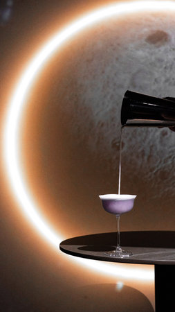 Pouring syrup into a glass on the background of the moon.の写真素材