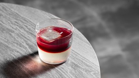 Panna cotta with berry sauce in a glass on a tableの写真素材