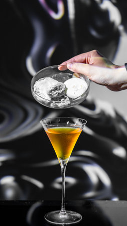 Cocktail in a martini glass with ice on a black backgroundの写真素材