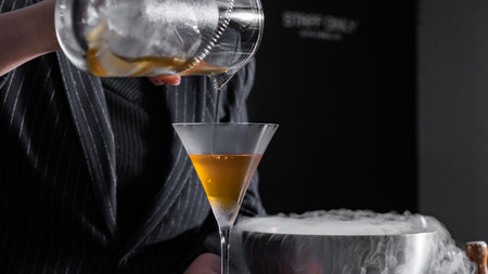 Bartender making cocktail in a bar, close-up.の写真素材